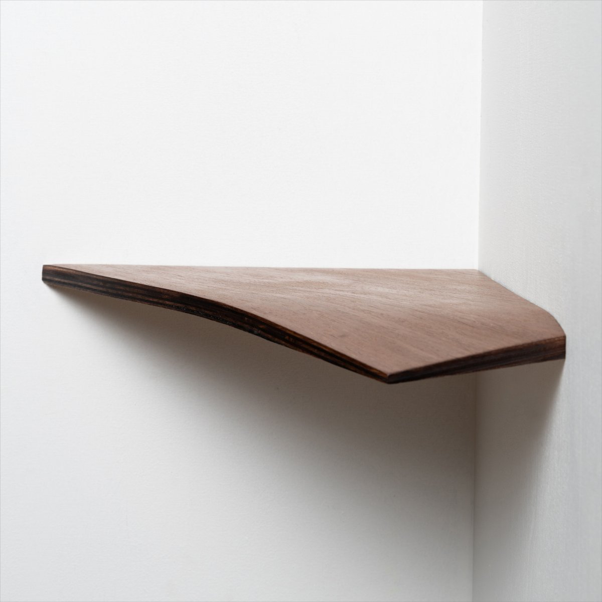 4. Walnut wood corner shelf mounted on a white wall, showcasing sleek design and craftsmanship