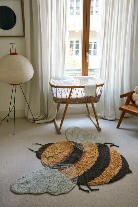 1. Bee-shaped rug in a nursery setting with a crib and chair, featuring honey and dark gray stripes and light blue wings
