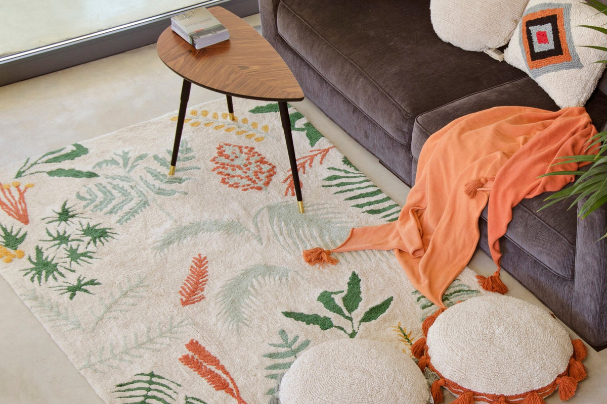 4. Tropical plant motif rug in a living room with a sofa, cushions, and a small table