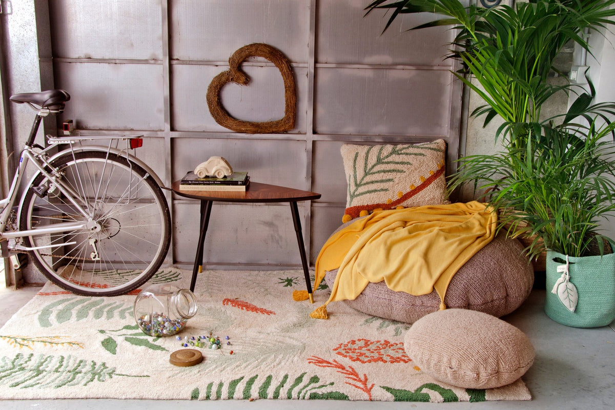 2. Botanical rug with tropical designs in a cozy corner with a bicycle, plants, and cushions