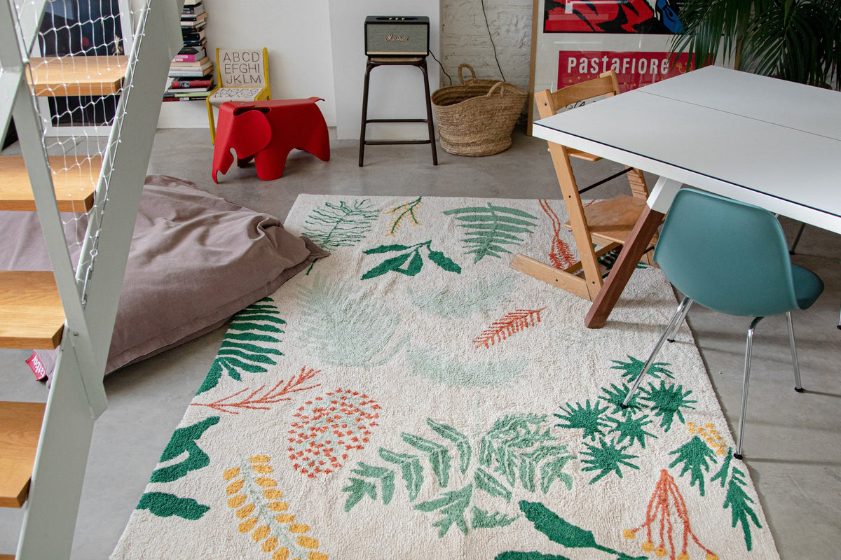 1. Washable rug with tropical plant motifs in a modern living room setting with colorful furniture and decor