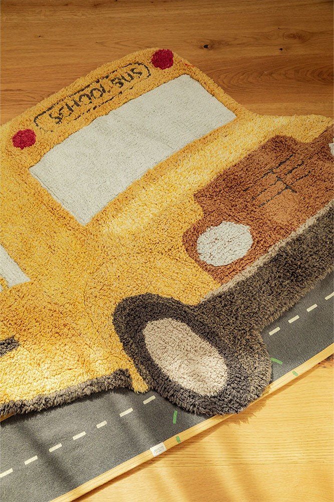 3. Close-up of yellow school bus rug on wooden floor, highlighting textured cotton material and detailed design