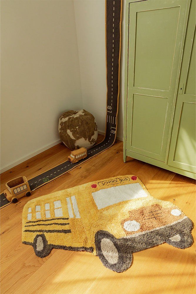 1. Yellow school bus-shaped cotton rug in a child's room with wooden floor and green cabinet, featuring playful design and textured details