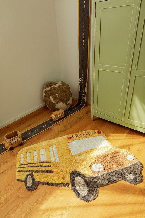1. Yellow school bus-shaped cotton rug in a child's room with wooden floor and green cabinet, featuring playful design and textured details