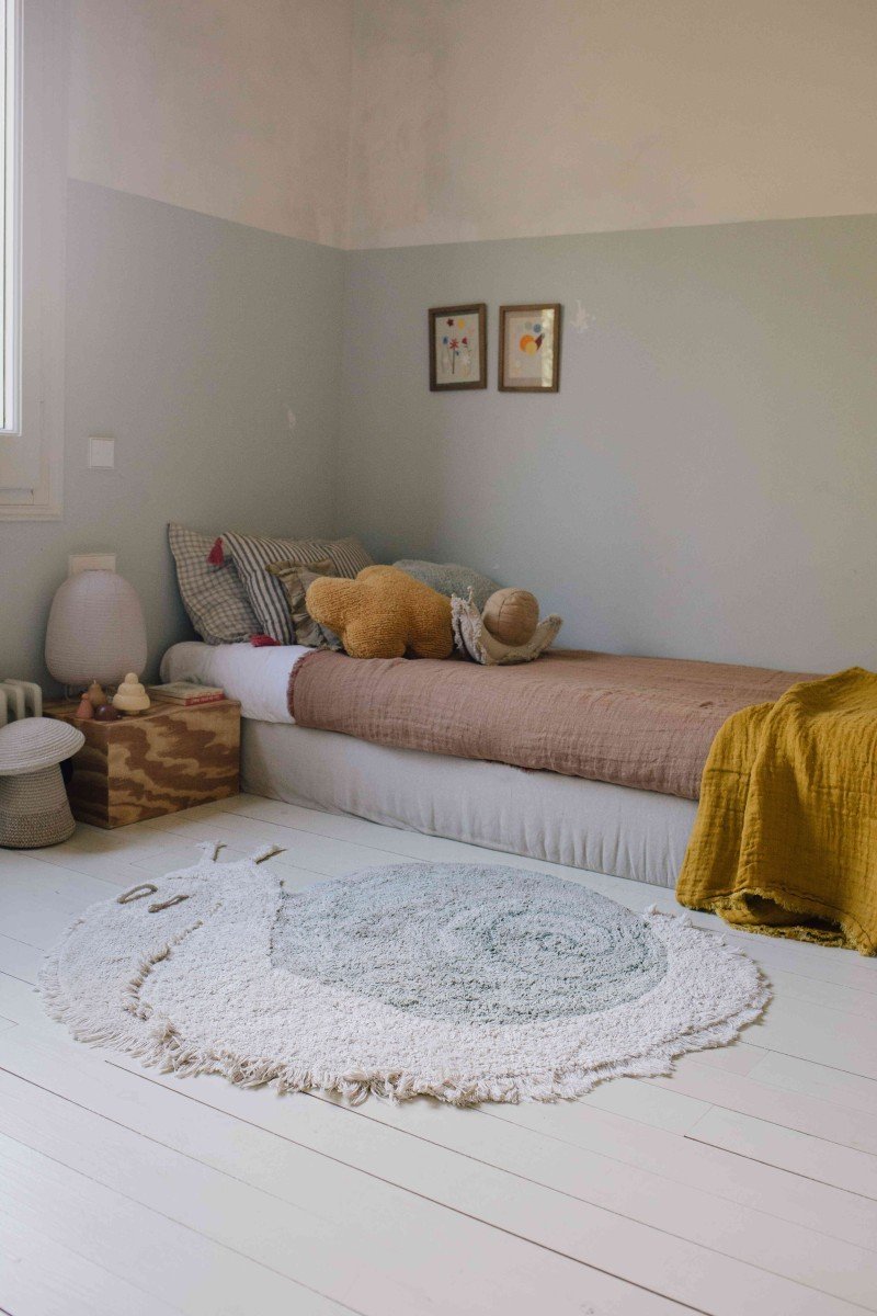 1. Snail-shaped rug in a children's room with a bed and decorative items