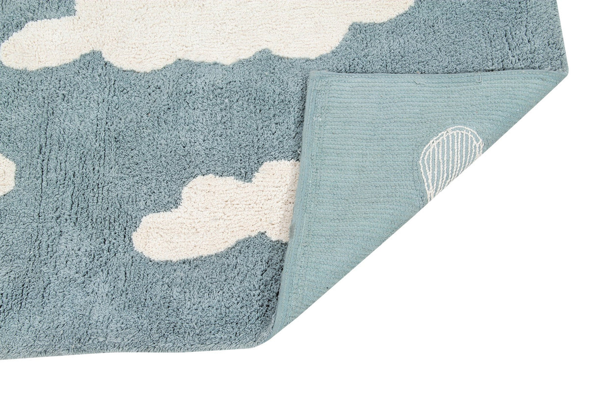 3. Detail of blue rug with white clouds, showing back corner with designer's signature