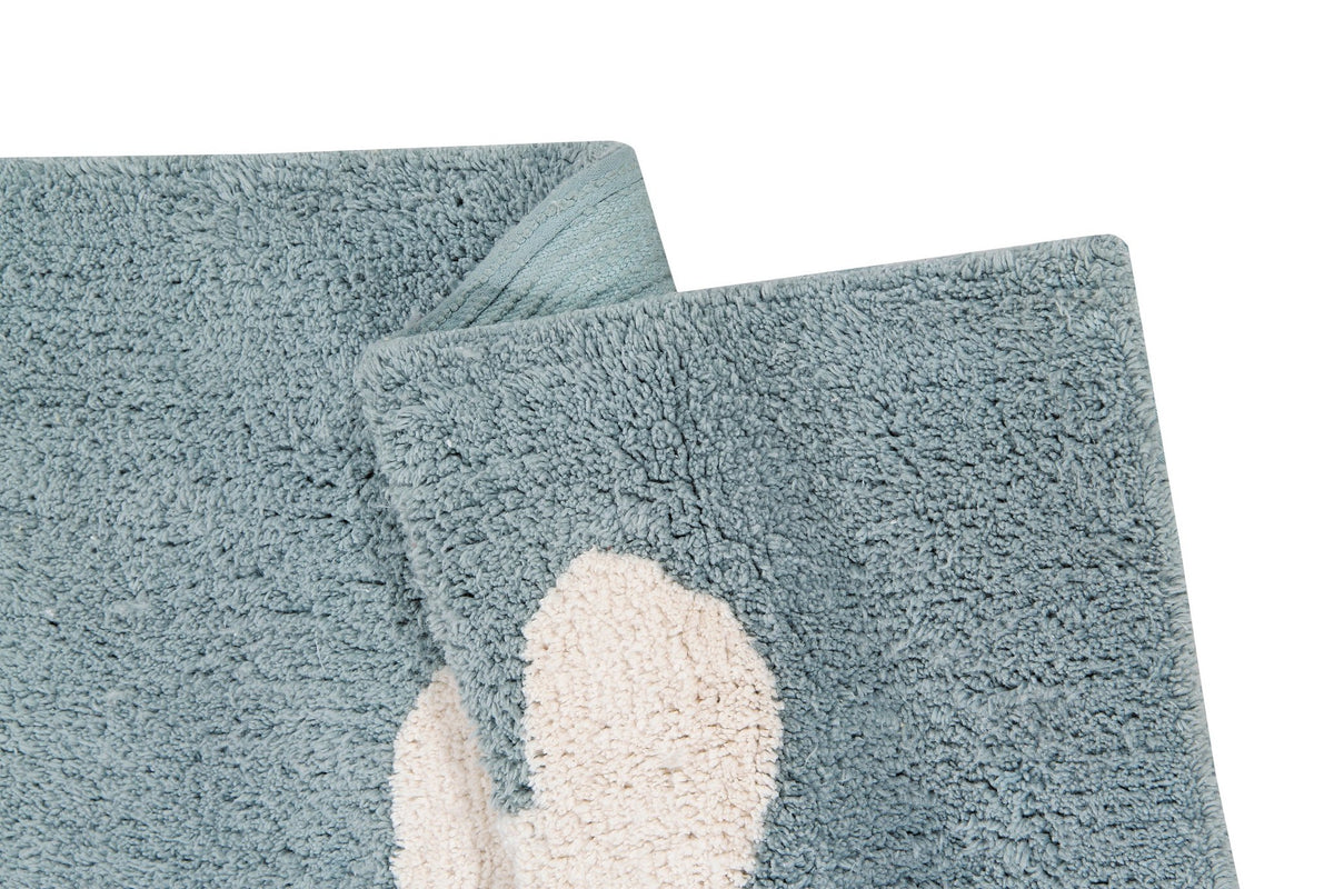 5. Detail of folded blue rug with white cloud design, highlighting fabric texture