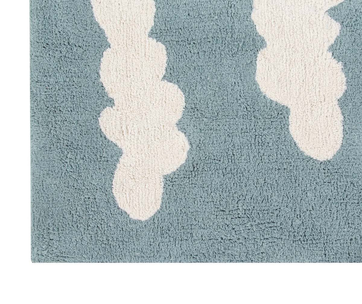 4. Close-up of blue rug with elongated white cloud pattern, showing texture