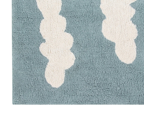 4. Close-up of blue rug with elongated white cloud pattern, showing texture
