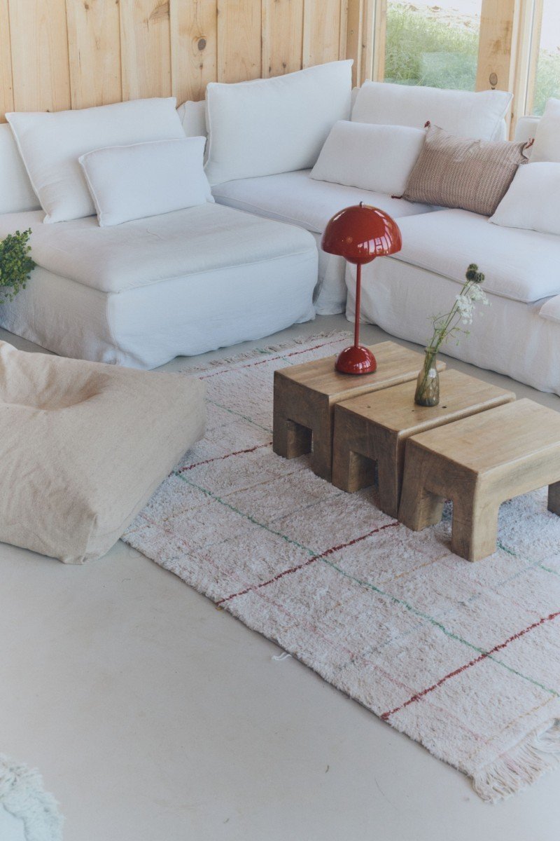 1. Natural multicolor striped rug in living room with white sofa, red lamp, and wooden tables