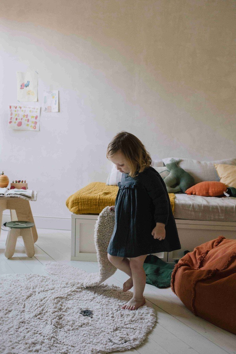 5. Child playing with natural and ivory bunny rug in a cozy room
