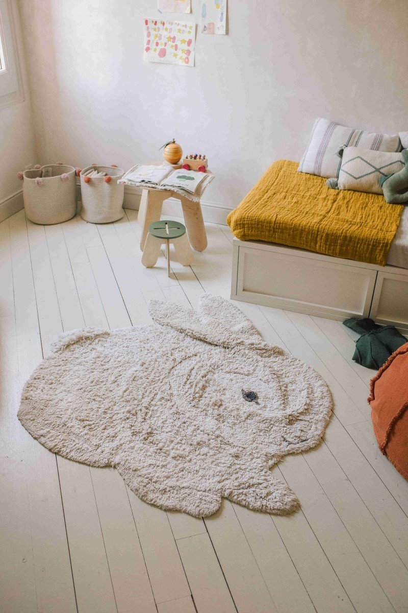 1. Bunny-shaped rug in natural and ivory colors on a wooden floor in a cozy room setting