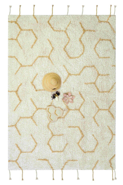 1. Ivory play rug with honeycomb pattern and four textile accessories including a beehive, bee, flower, and honeycomb on a wooden floor in a child's room