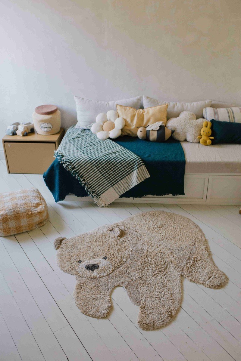 4. Teddy bear rug in room with bed and cushions, creating a cozy atmosphere