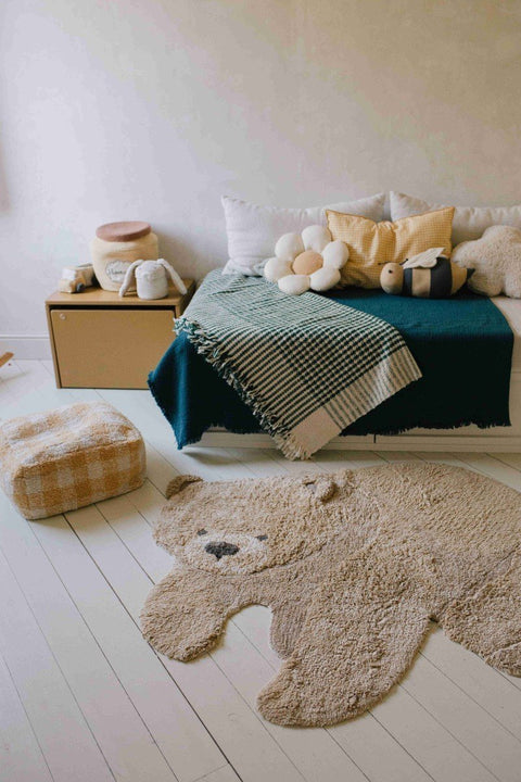 2. Teddy bear rug in cozy room setting with bed, cushions, and pouf on white wooden floor