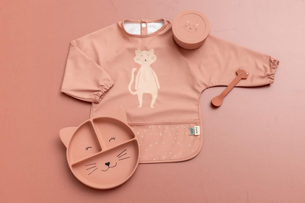 4. Flat lay of pink waterproof long sleeve bib with cat print, accompanied by matching cat-themed plate, cup, and spoon