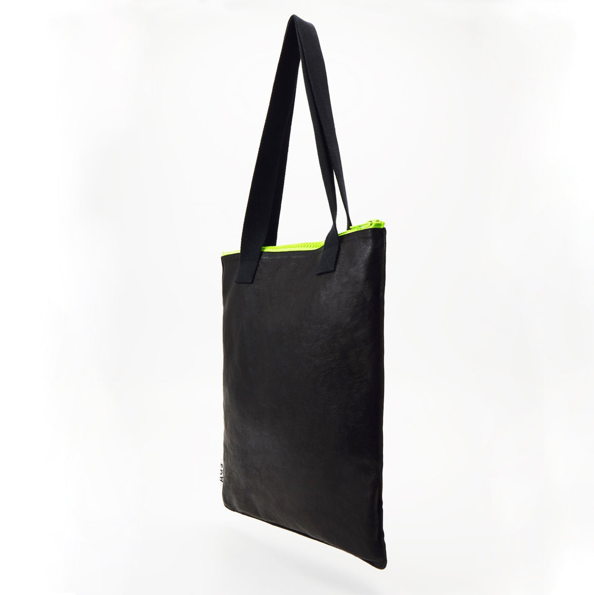3. Side view of Daz Studio black leather tote with neon green zipper and durable construction