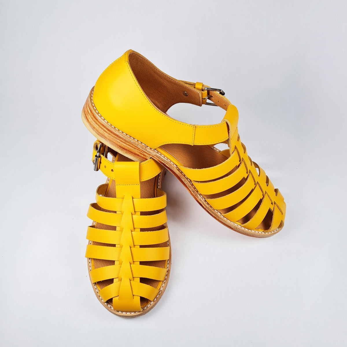 4. Side view of Daz Studio's yellow handmade leather fisherman sandals with stacked heel
