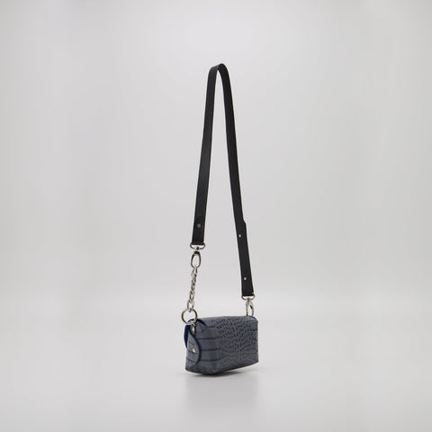 5. Studio image of Daz Studio's grey and blue leather shoulder bag with long adjustable strap, highlighting sleek design
