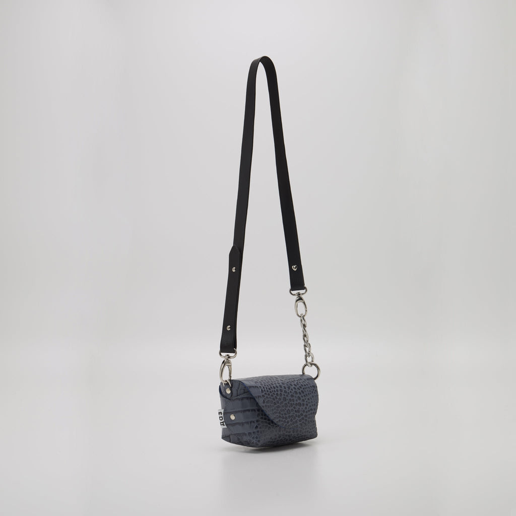 6. Studio shot of Daz Studio's grey and blue textured leather shoulder bag with adjustable strap, showcasing compact size