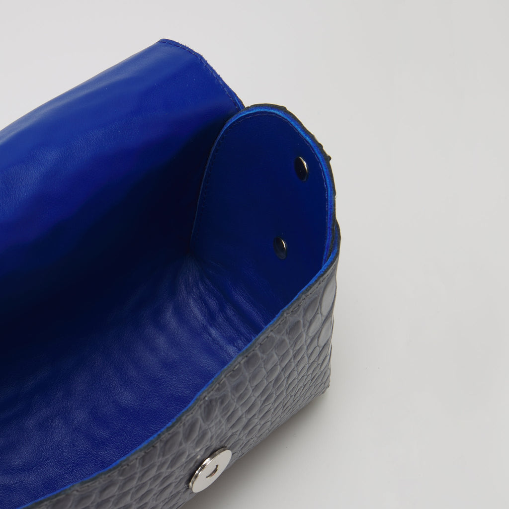 9. Interior view of Daz Studio's grey and blue leather shoulder bag, highlighting royal blue leather lining