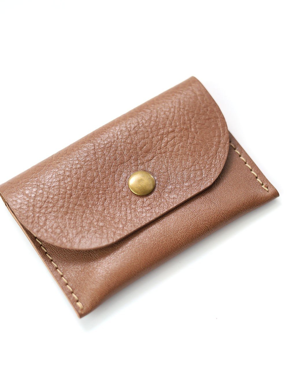 2. Angled view of Toks Visoks WEEKEND wallet in cappuccino leather showing texture and brass button
