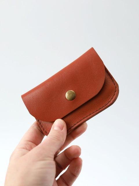5. Hand holding red clay leather wallet by Toks Visoks, highlighting size and texture