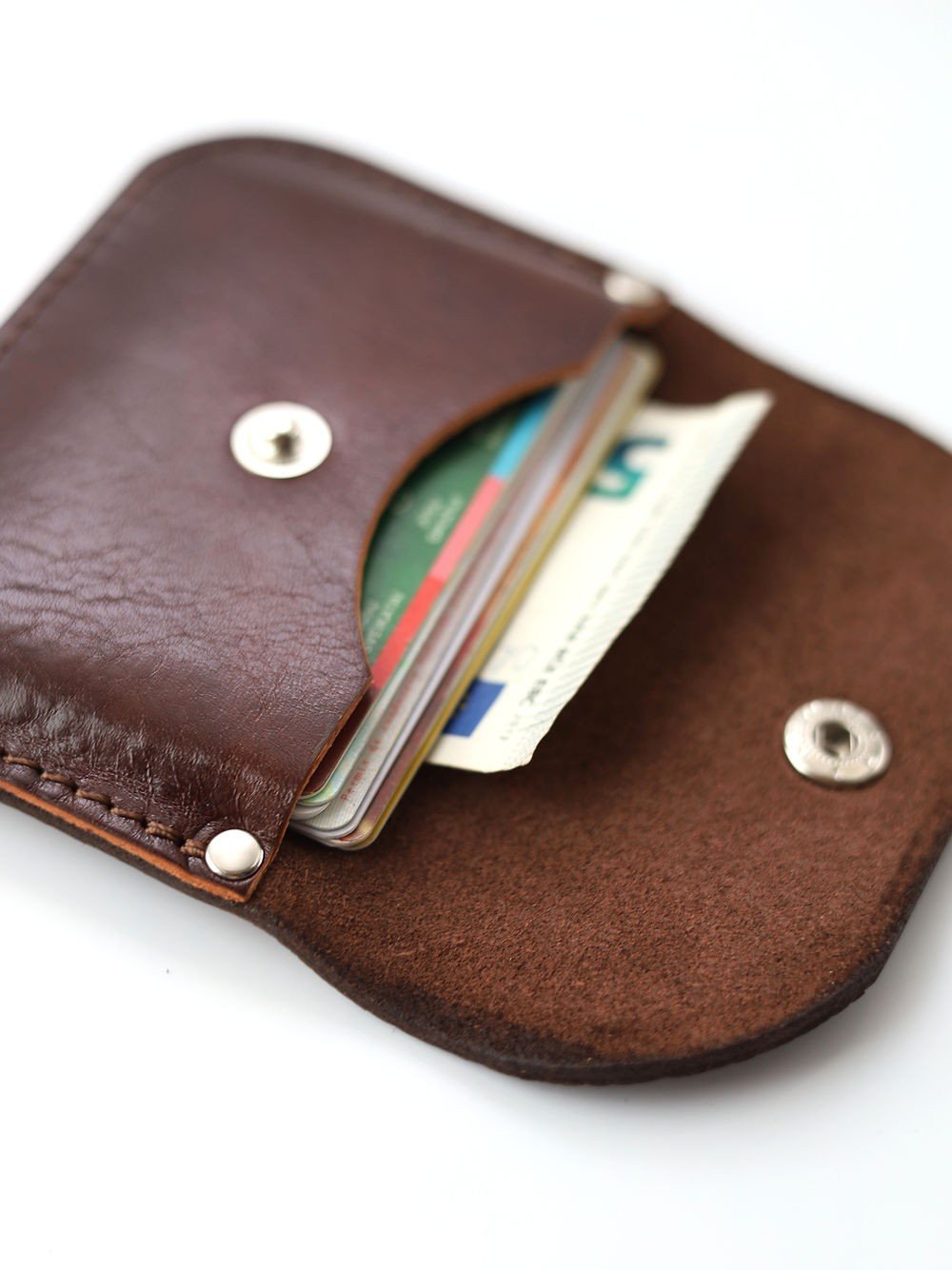 4. Close-up of open Toks Visoks brown and chestnut leather wallet with visible cards and snap closure