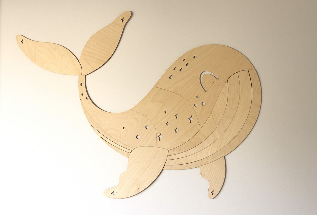 2. Wooden whale wall decoration on a plain beige wall showing detailed carving