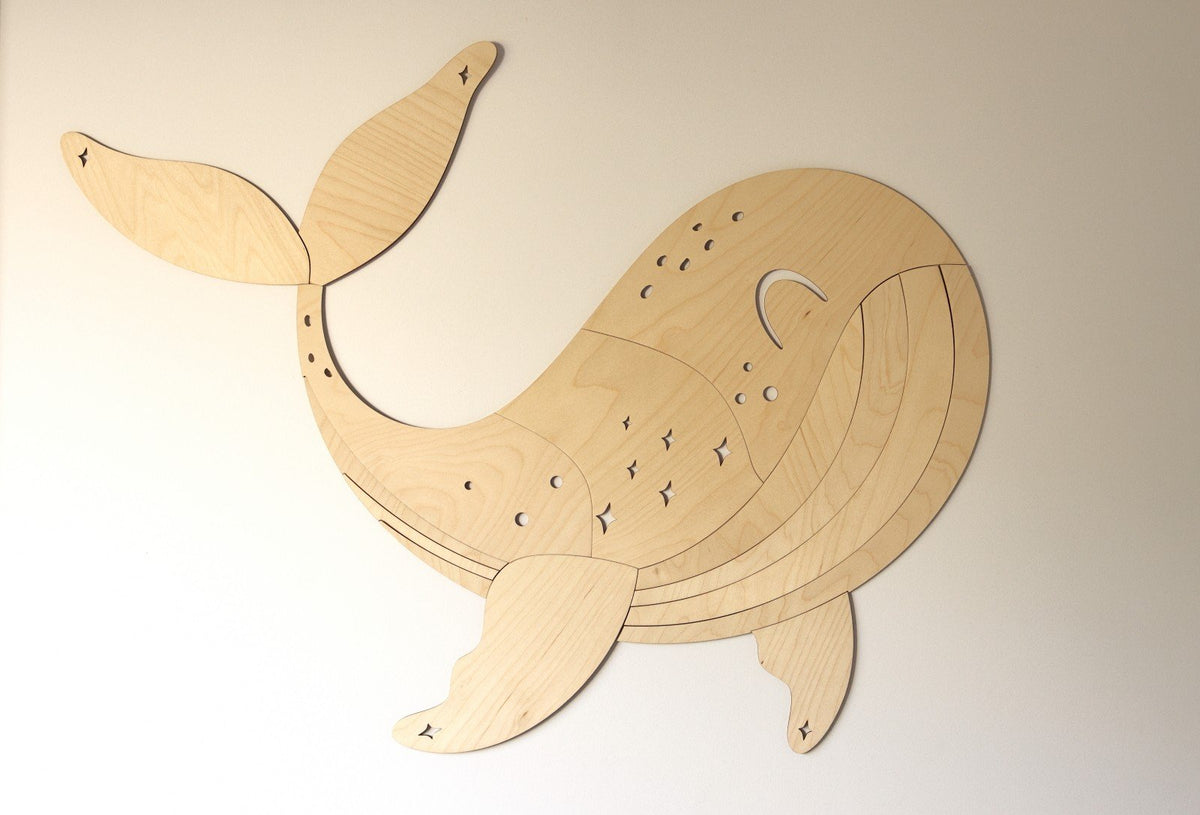 2. Wooden whale wall decoration on a plain beige wall showing detailed carving