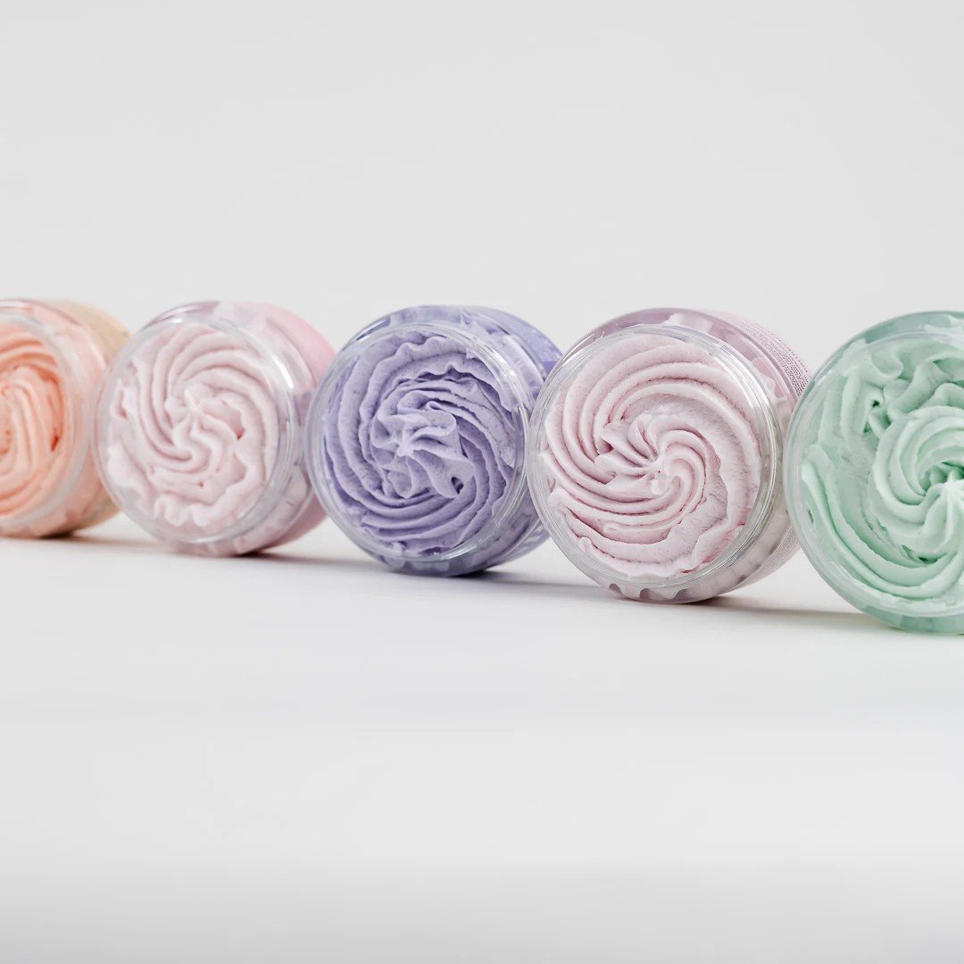 3. Top view of North Beauty whipped sugar body scrubs in pastel colors, arranged in a row