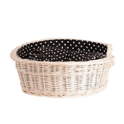 2. Rear view of whitewashed wicker dog bed with black polka dot cushion, emphasizing sturdy construction