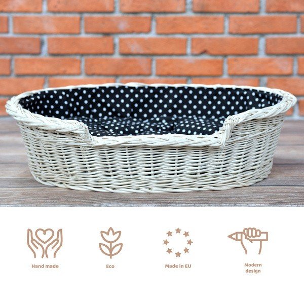 1. Whitewashed wicker dog bed with black polka dot cushion, outdoor setting with brick wall background