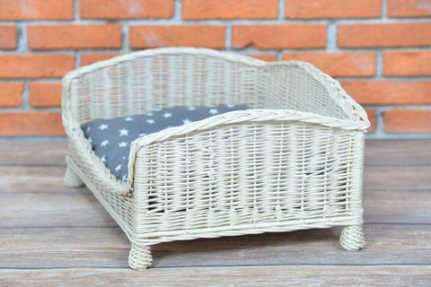 3. Side view of whitewashed wicker pet bed with grey star-patterned cushion