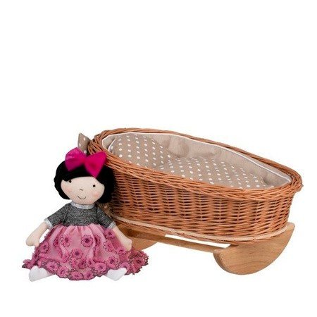 1. Wicker rocking cradle with beige checkered bedding and a doll in a pink dress beside it