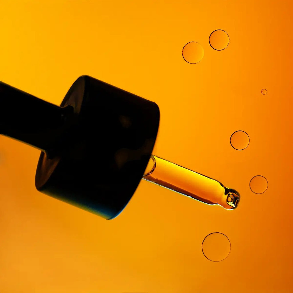 3. Close-up of Usva Cosmetics Wild Fruit Oil Serum dropper with oil droplets, showcasing texture and color