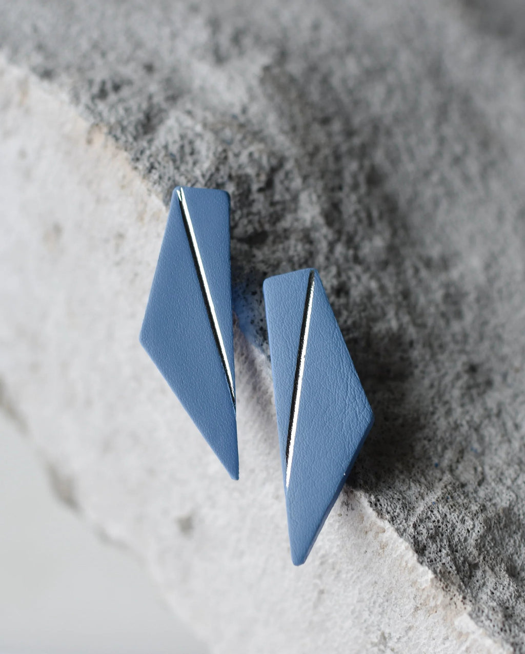 2. Light blue Gerda Retter Design Short Wings Earrings on textured surface, highlighting geometric design