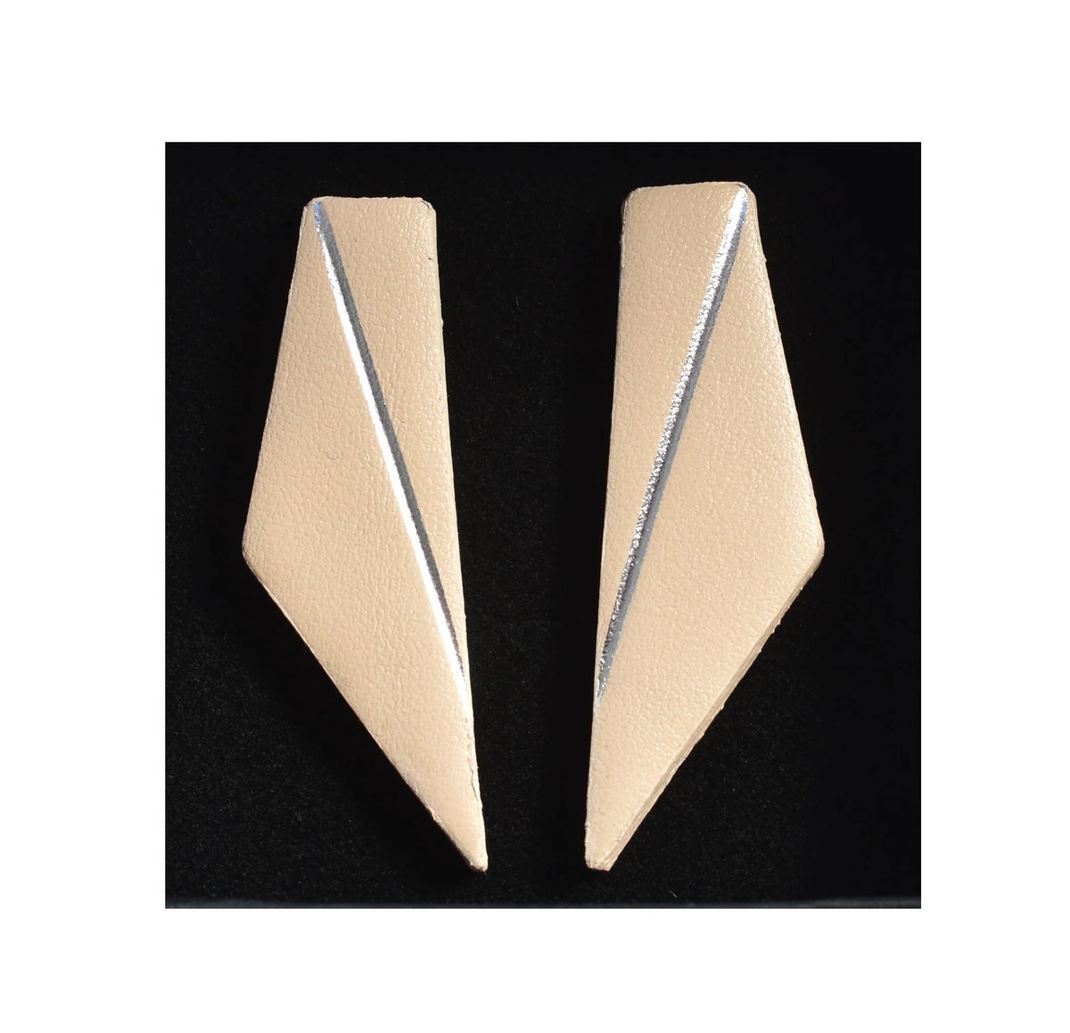 8. Beige Gerda Retter Design Short Wings Earrings on black background, showcasing geometric elegance