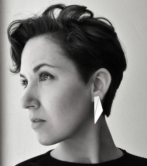 1. Woman wearing Gerda Retter Design Short Wings Earrings in white, showcasing geometric elegance
