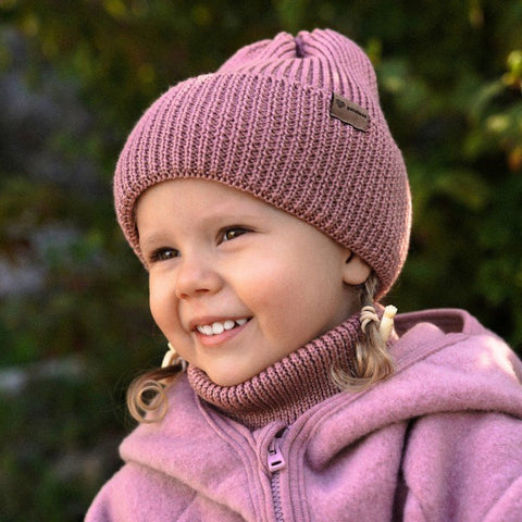 2. Smiling child in blush merino wool hat and neck warmer outdoors