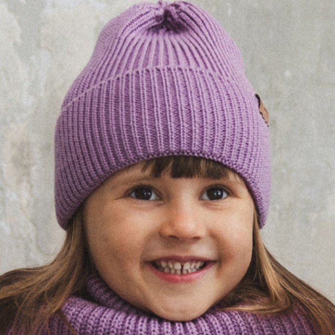 6. Close-up of child smiling in lilac merino wool hat and scarf against light background