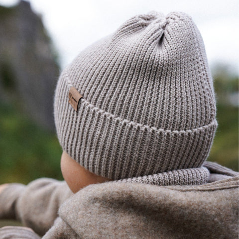3. Back view of child wearing Patulove oat-colored merino wool hat outdoors