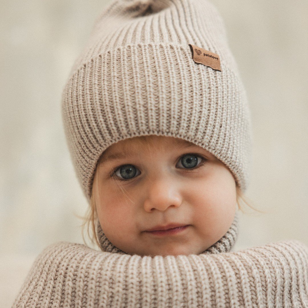 6. Close-up of child wearing Patulove oat-colored merino wool hat and neck warmer indoors