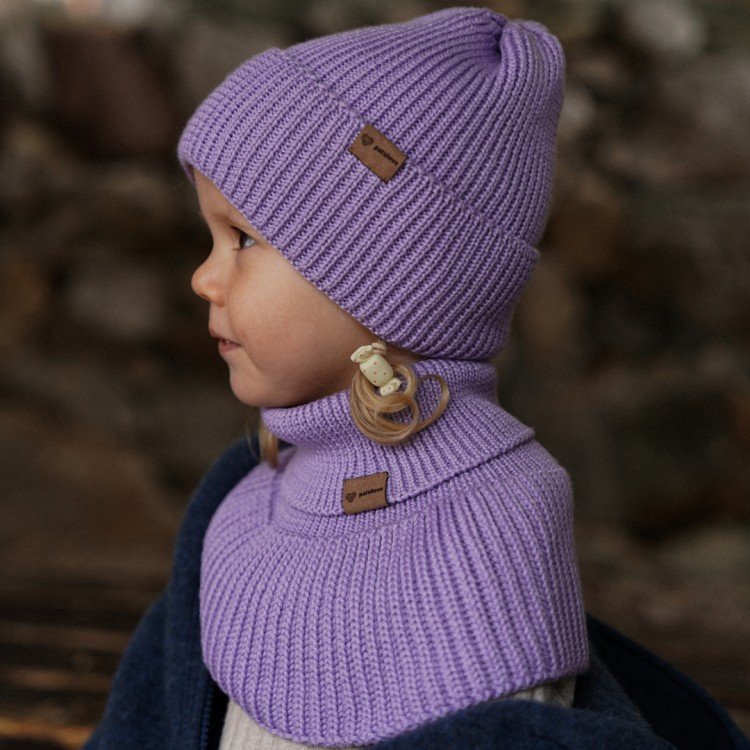 4. Child wearing lavender merino wool tube scarf and hat by Patulove, side view, showing ribbed texture and brand label, in warm indoor setting