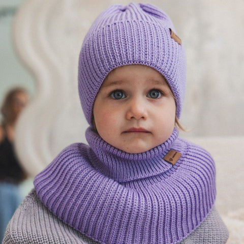 3. Child wearing lavender merino wool tube scarf and hat by Patulove, front view, highlighting ribbed texture and brand label, in bright indoor setting