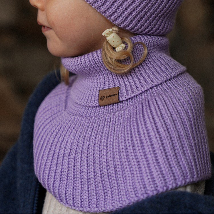 1. Child wearing lavender merino wool tube scarf and matching hat by Patulove, side view, showing ribbed texture and brand label, in cozy indoor setting