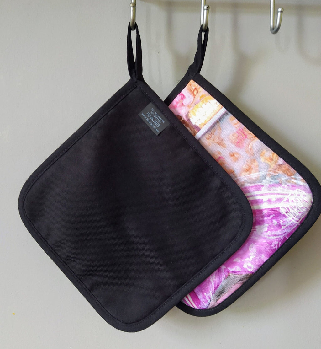 2. Back view of Katrin Valgemäe pot holder set, showing plain black side and pop art design side with hanging loops