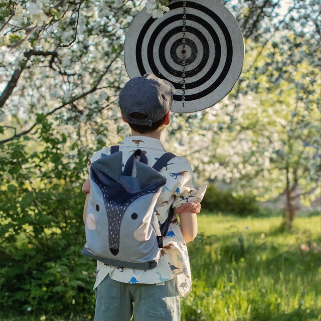 2. Boy with Muni wolf backpack in nature, highlighting adventurous spirit