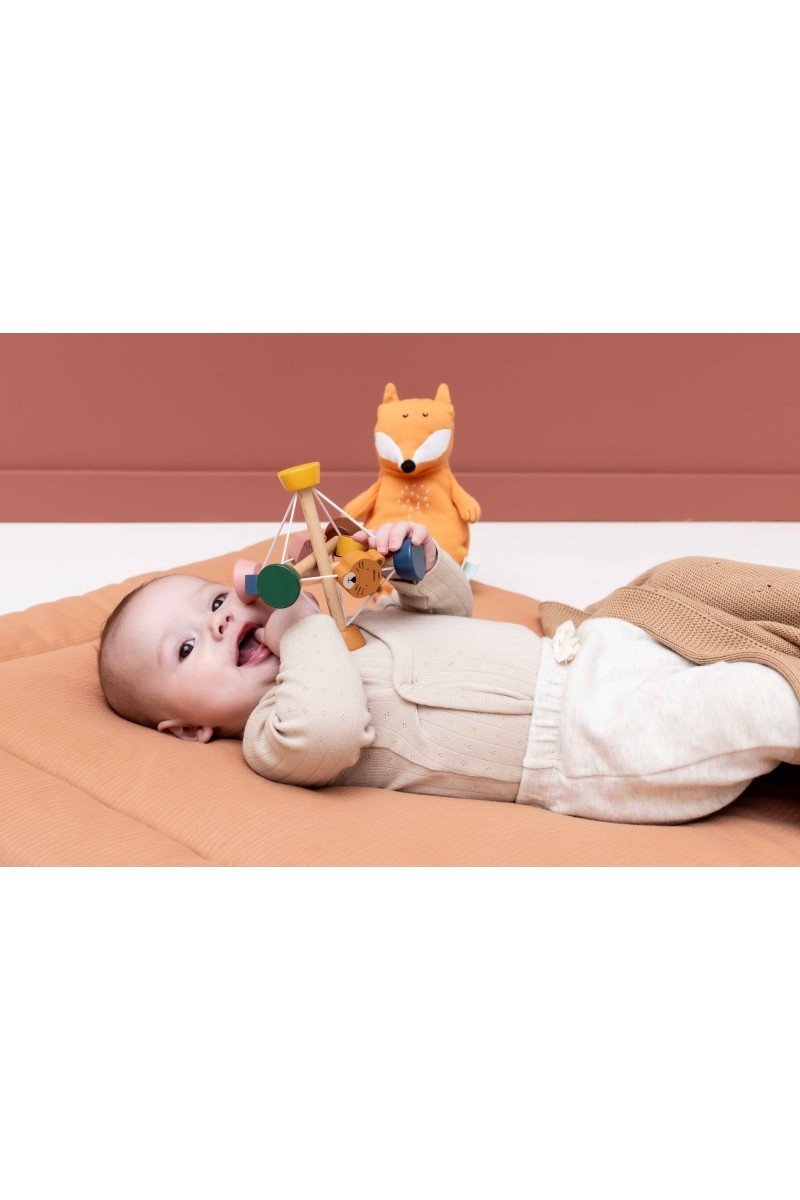 1. Baby playing with Trixie Baby Wooden Activity Ball on soft mat, featuring colorful animal beads