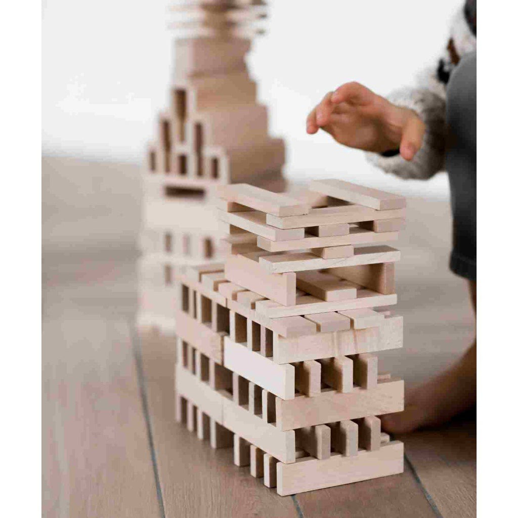 3. Close-up of child's hand arranging Wooden Story blocks, highlighting smooth texture and natural wood color